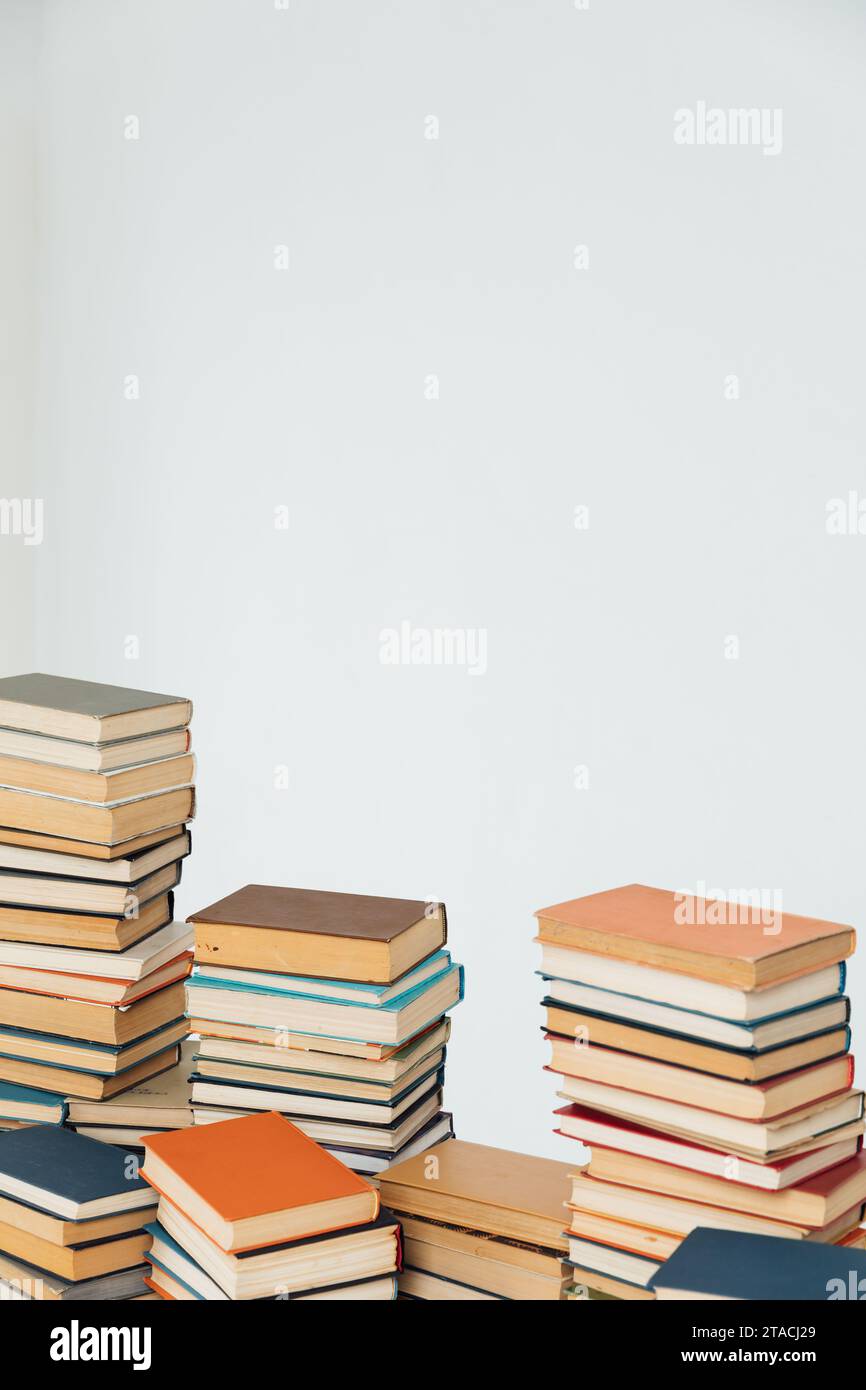 Viele Stapel alter Lehrbücher in der Universitätsbibliothek mit weißem Hintergrund Stockfoto