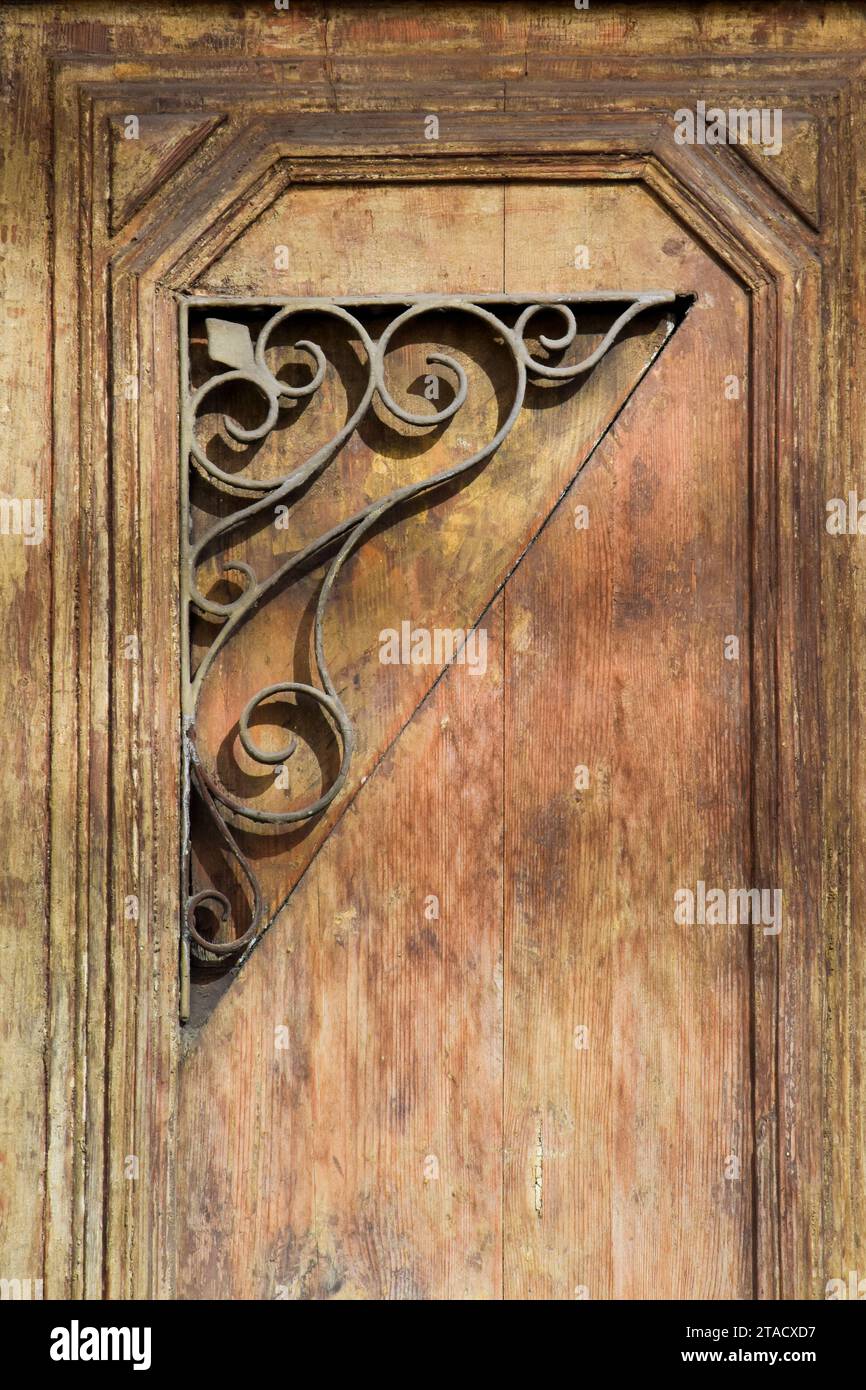 Schmiedeeiserne Ornamente an einer Holztür. Stockfoto