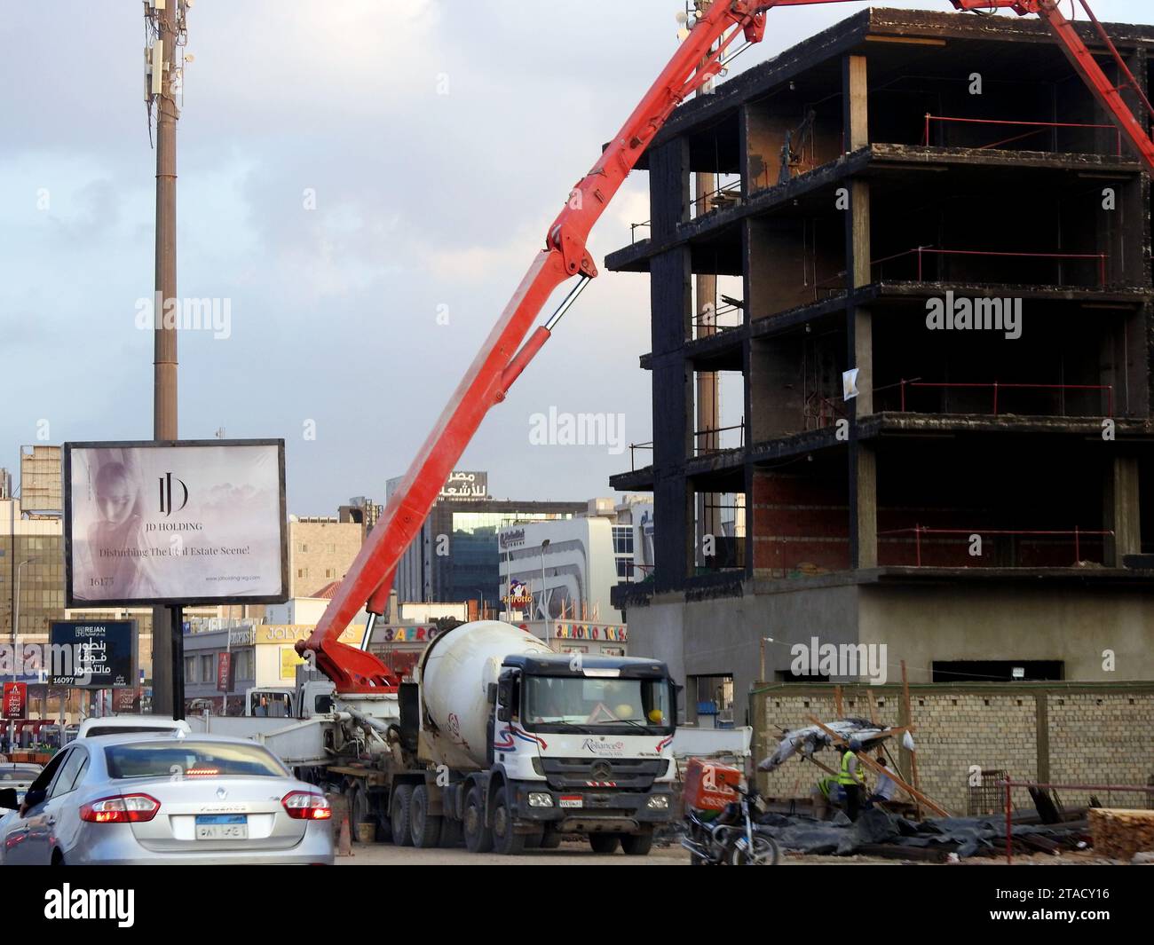 Kairo, Ägypten, 14. November 2023: Eine Lkw-Betonauslegerpumpe am Straßenrand, die Beton in ein neues Gebäude gießt, selektiver Betonfokus Stockfoto