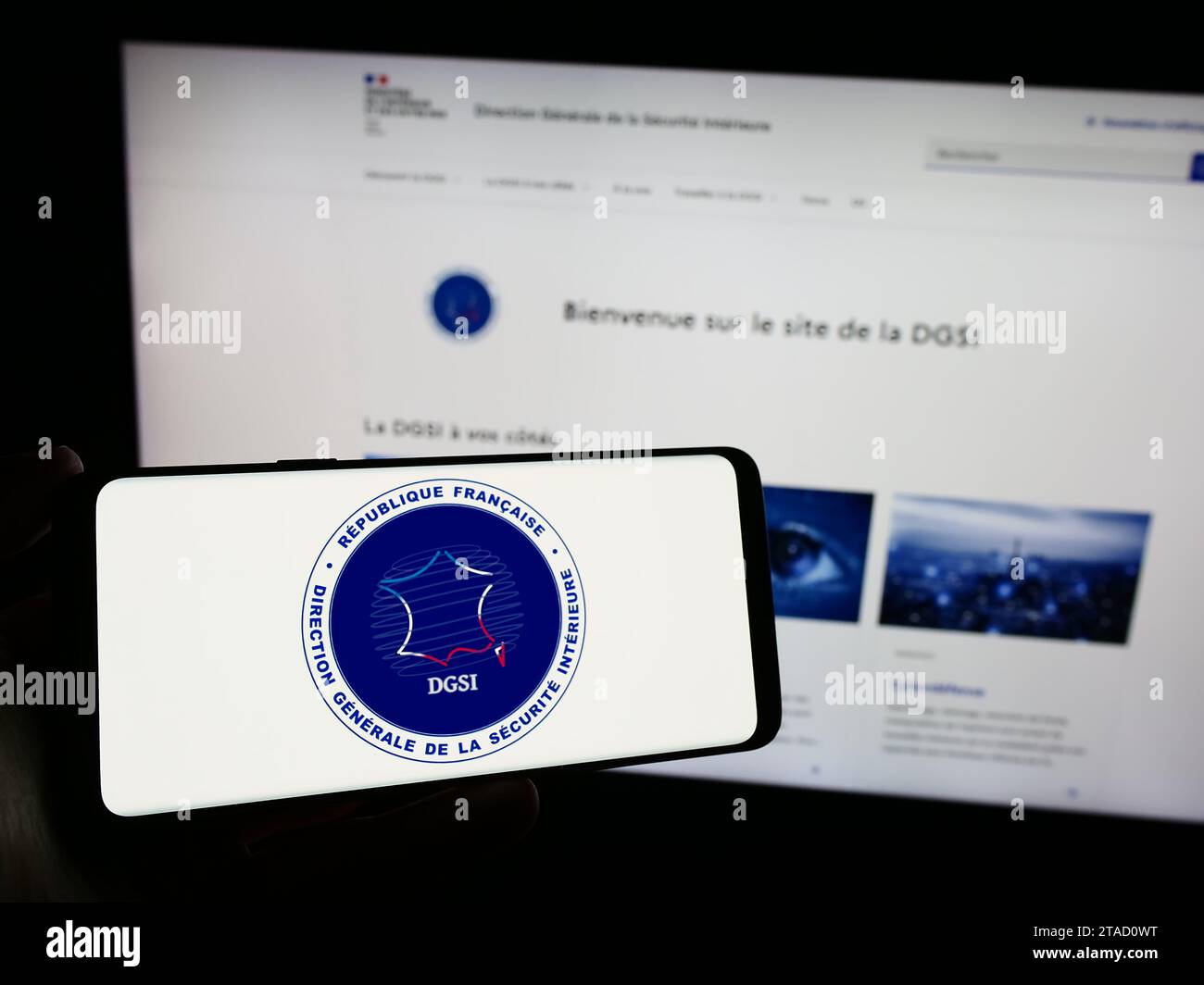 Person mit Smartphone und Logo der Richtung Générale de la Sécurité Intérieure (DGSI) vor der Website. Schwerpunkt auf dem Display des Telefons. Stockfoto