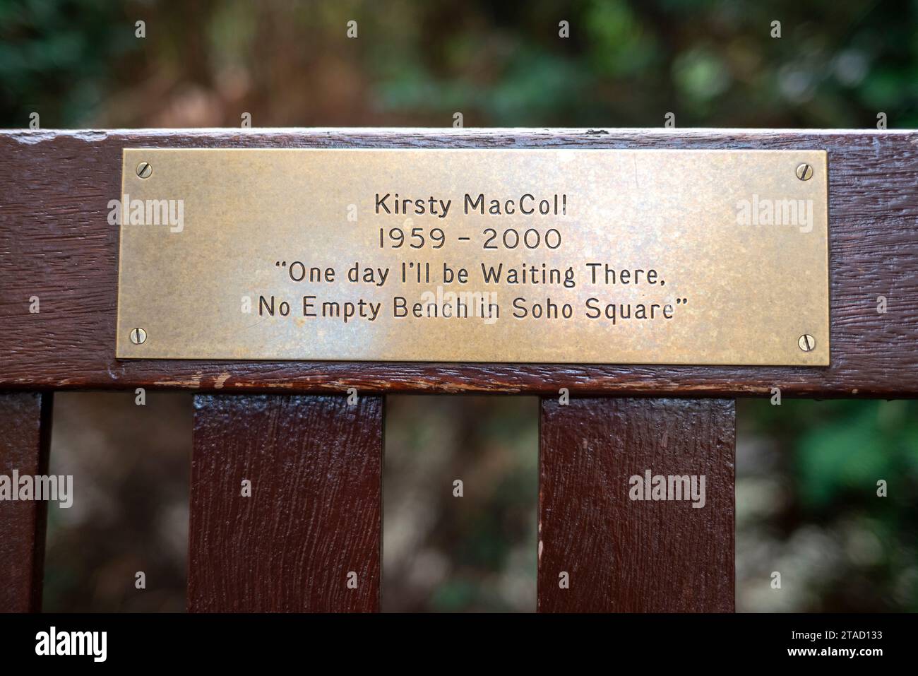 Plakette auf einer Bank zum Gedenken an die Sängerin Kirsty MacColl am Soho Square, London Stockfoto