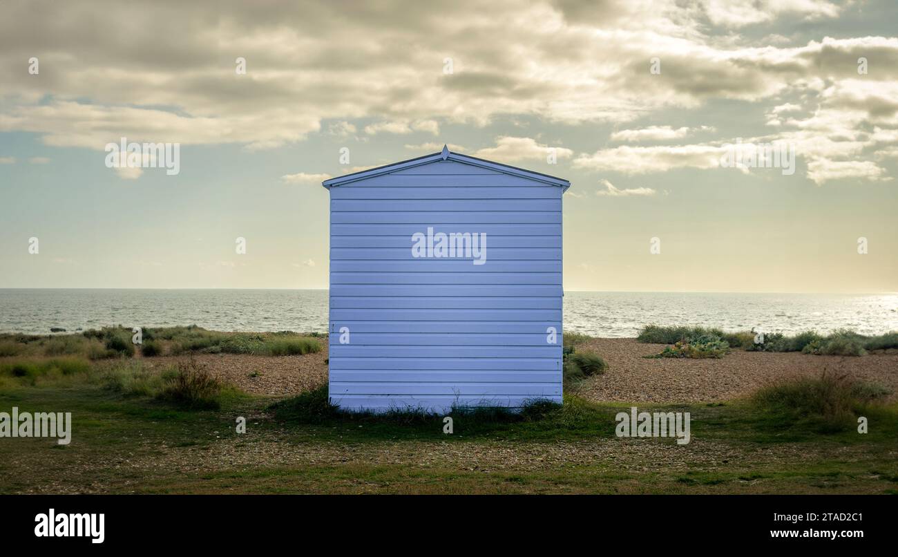 Einzelnes hölzernes Strandhaus an einem Kiesstrand mit Blick auf das Meer. Stockfoto