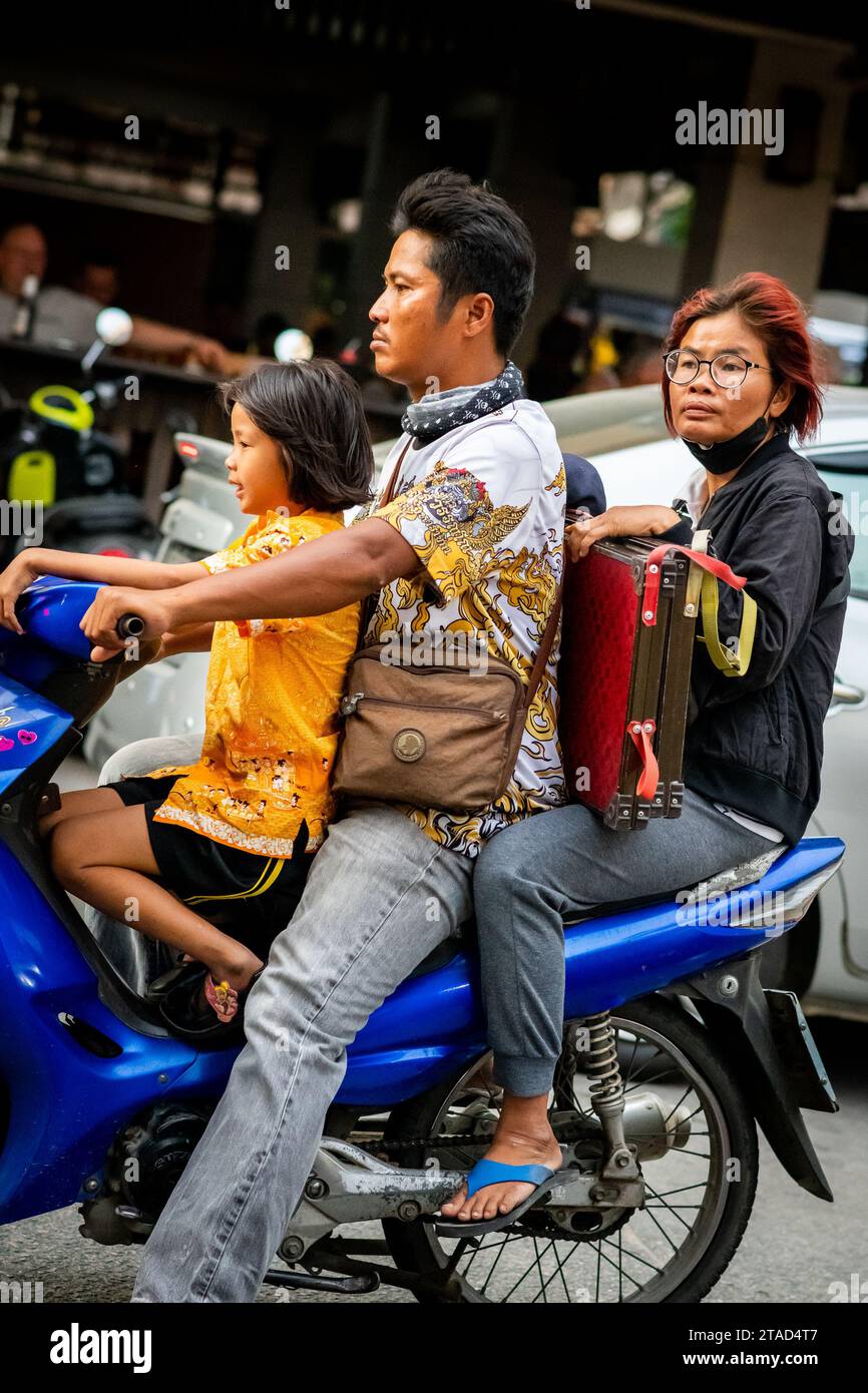 Eine thailändische Familie reist mit ihrem Motorrad durch die geschäftigen Straßen von Pattaya City, Thailand. Stockfoto
