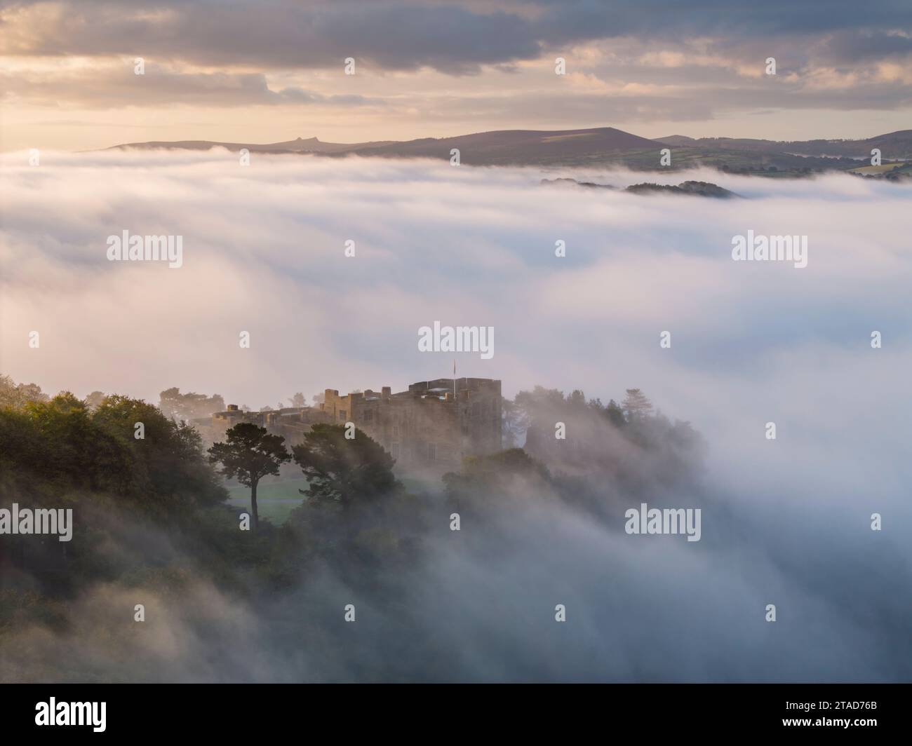 Aus der Vogelperspektive auf Castle Drogo, das aus einem Meer aus Morgennebel auftaucht, Dartmoor National Park, Devon, England. Herbst (Oktober) 2023. Stockfoto