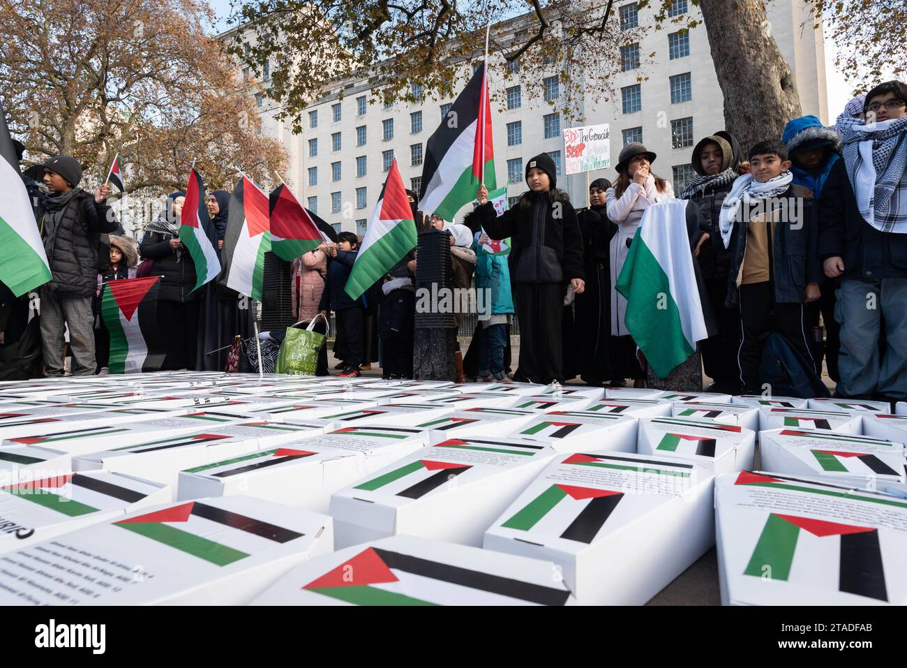 London, Großbritannien. 30. November 2023. Palästinensische Unterstützer der in Großbritannien ansässigen NGO Friends of Al-Aqsa legen gegenüber der Downing Street Hunderte von kleinen symbolischen Särgen ab, die die Tausende von Kindern repräsentieren, die Israel seit Beginn des Krieges gegen Gaza nach Angriffen von Hamas-Milizen getötet hat. Die Gruppe forderte einen dauerhaften Waffenstillstand und ein Ende der Belagerung und Besetzung des Gazastreifens und des Westjordanlands. Quelle: Ron Fassbender/Alamy Live News Stockfoto