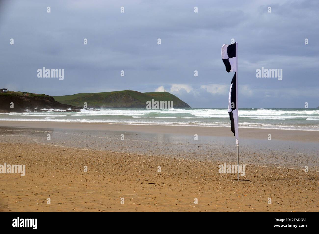 Stepper Point Tower ein Stone Daymark Navigation Beacon „The Pepper Pot“ von einer RNLI Black & White Chequered Beach Flag Hayle Bay in der Nähe von Polzeath. Stockfoto