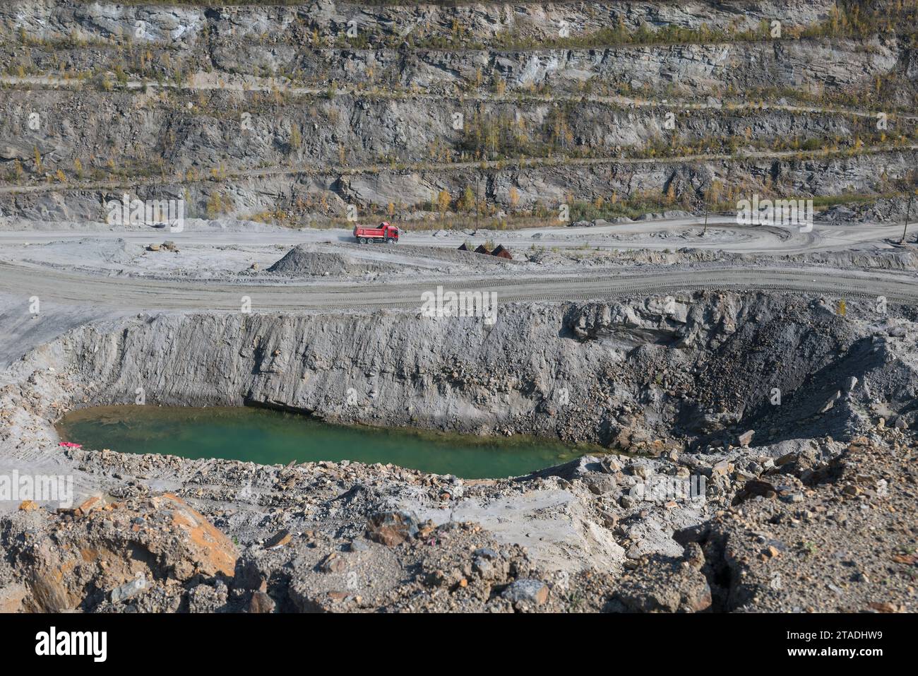 Ein Panoramablick auf einen Bergbaustandort mit schweren Maschinen und Arbeitern, die wertvolle Mineralien aus Gesteinen gewinnen, was die Karrieremöglichkeiten bei unterstreicht Stockfoto