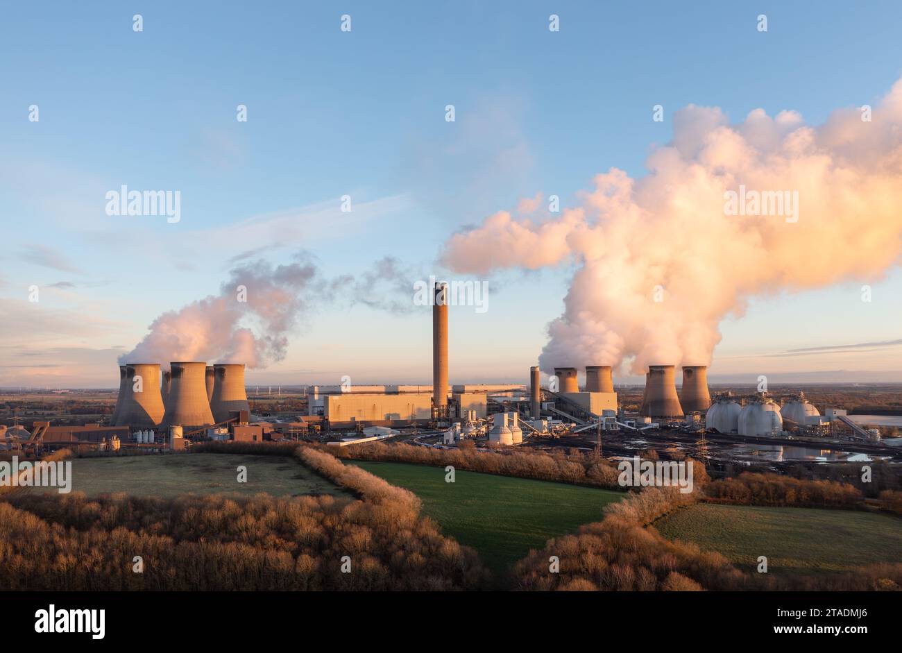 DRAX, YORKSHIRE, GROSSBRITANNIEN - 29. NOVEMBER 2023. Drax Kohlekraftwerk in North Yorkshire, Großbritannien mit Kohlestapel und Biomasselagertanks bei Sonnenuntergang mit c Stockfoto