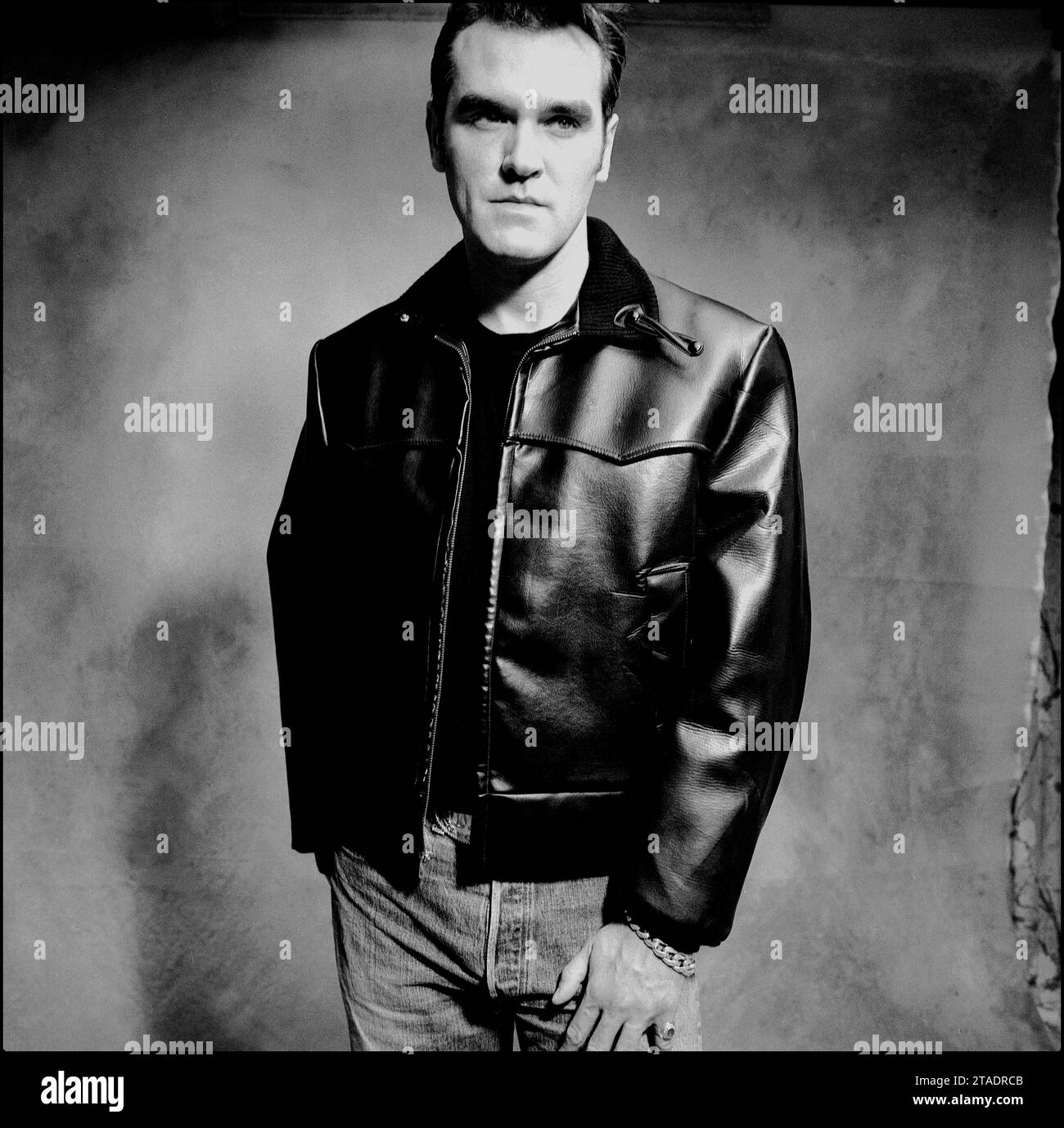 Das leistungsstarke Schwarzweiß-Porträt des legendären Rockstars, Sängers/Songwriters Morrissey in Lederjacke und blauer Jeans, um 1995 für Parlophone Records seine Single Sunny zu bewerben. Stockfoto