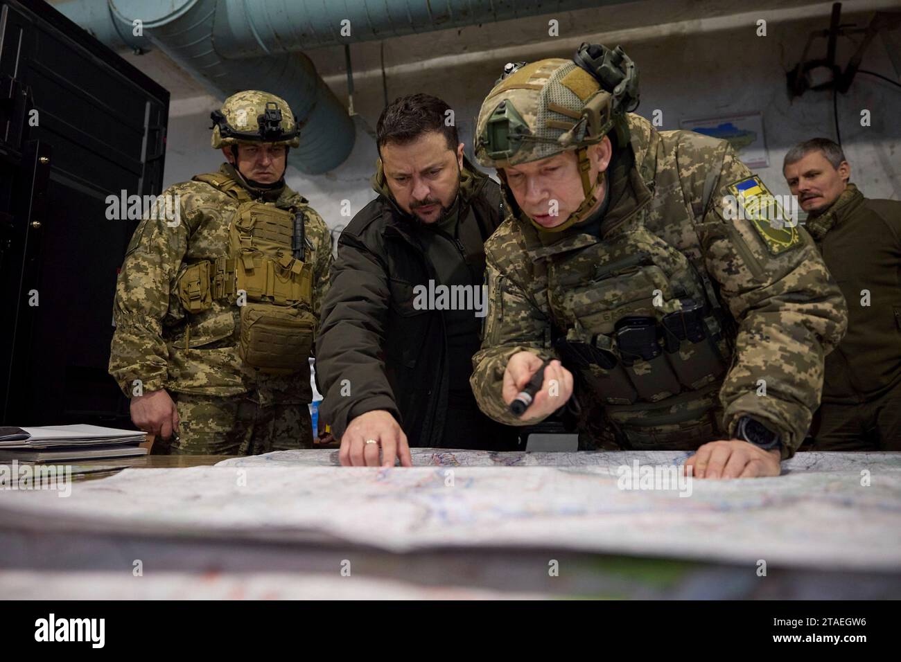 Kupjansk, Ukraine. November 2023 30. Der ukrainische Präsident Wolodymyr Zelenskyj, Zentrum, wird während eines Besuchs an einem Kommandoposten an der Frontlinie in der Region Charkiw am 30. November 2023 in Kupjansk, Region Charkiw, Ukraine, über die Lage entlang der Verteidigungslinie Kupjansk-Lyman informiert. Von links nach rechts: Taktische Gruppe Kupjansk, Oleksandr Lutsenko, Präsident Wolodymyr Zelenskij und Befehlshaber der Bodenstreitkräfte Oleksandr Syrskyi. Quelle: Pool Photo/Ukrainische Präsidentenpresse/Alamy Live News Stockfoto