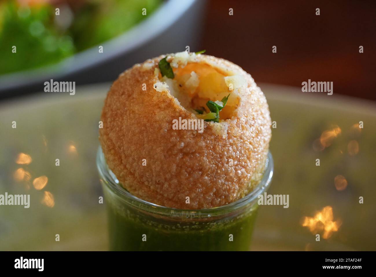 Pani puri Shot, auch bekannt als Golgappa Shot oder Gol Gappe Shot, ein vielseitiger Snack, der in Indien erfunden wurde und aus gefüllten Pani puri (Golgappa) auf einem flüssigkeitsgefüllten Shot-Glas besteht. Stockfoto