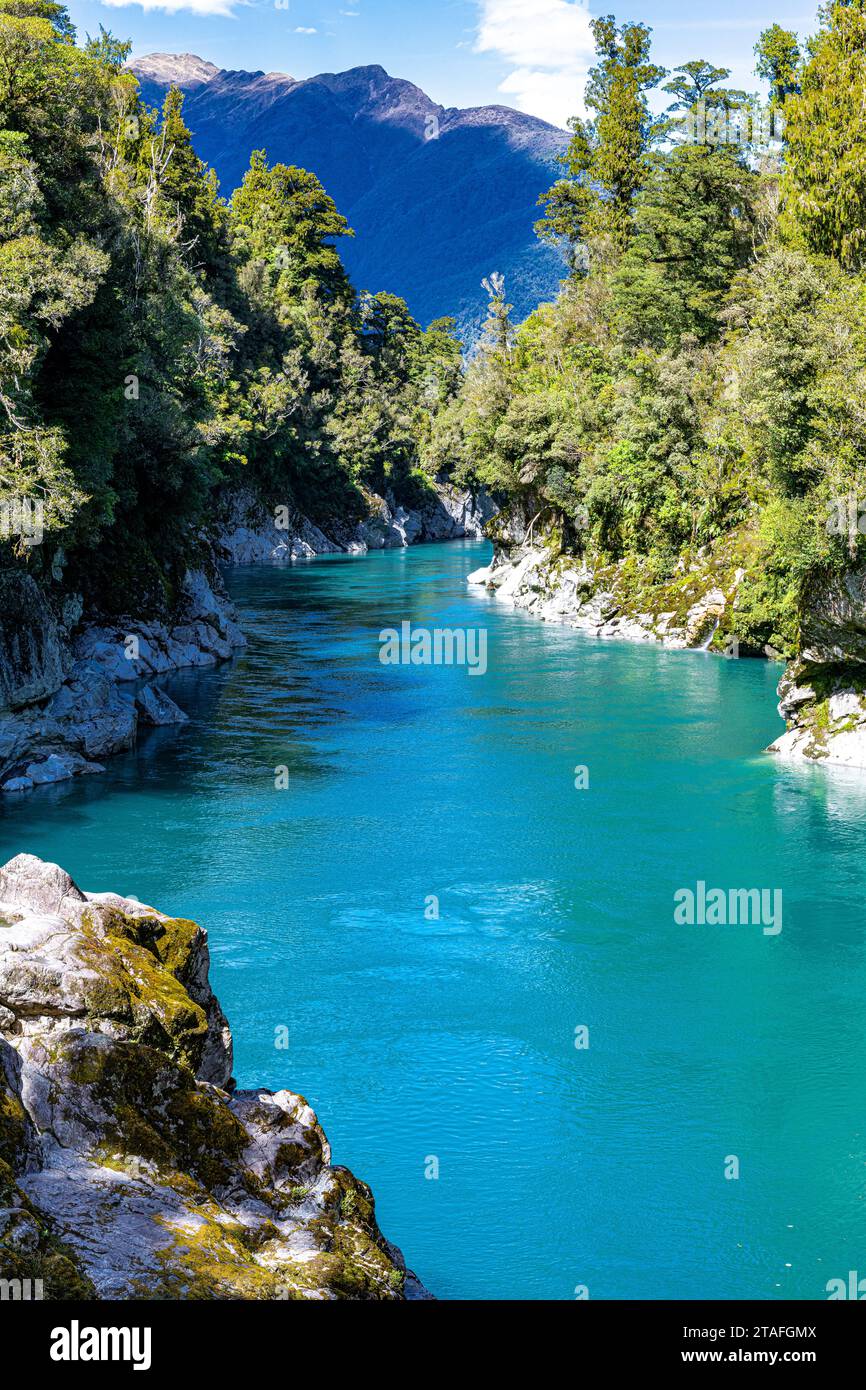 Türkisfarbenes Wasser fließt durch die Hokitika Gorge inmitten üppiger Vegetation und Felsformationen. Stockfoto