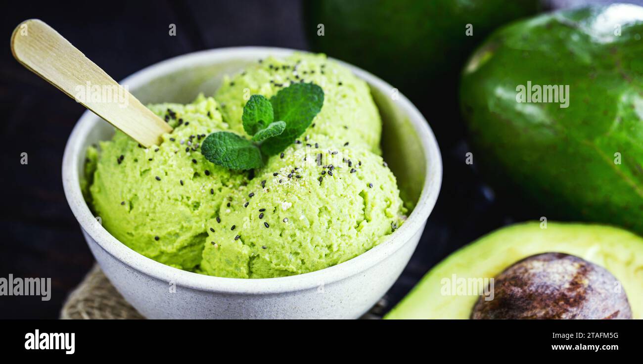 Hausgemachtes Avocado-Eis, hergestellt aus gefrorenen Bio-Früchten ohne Zusatz von Zucker oder Milchprodukten. Veganes Dessert. Dessert in biologisch abbaubarer Plastikschüssel serviert. Stockfoto