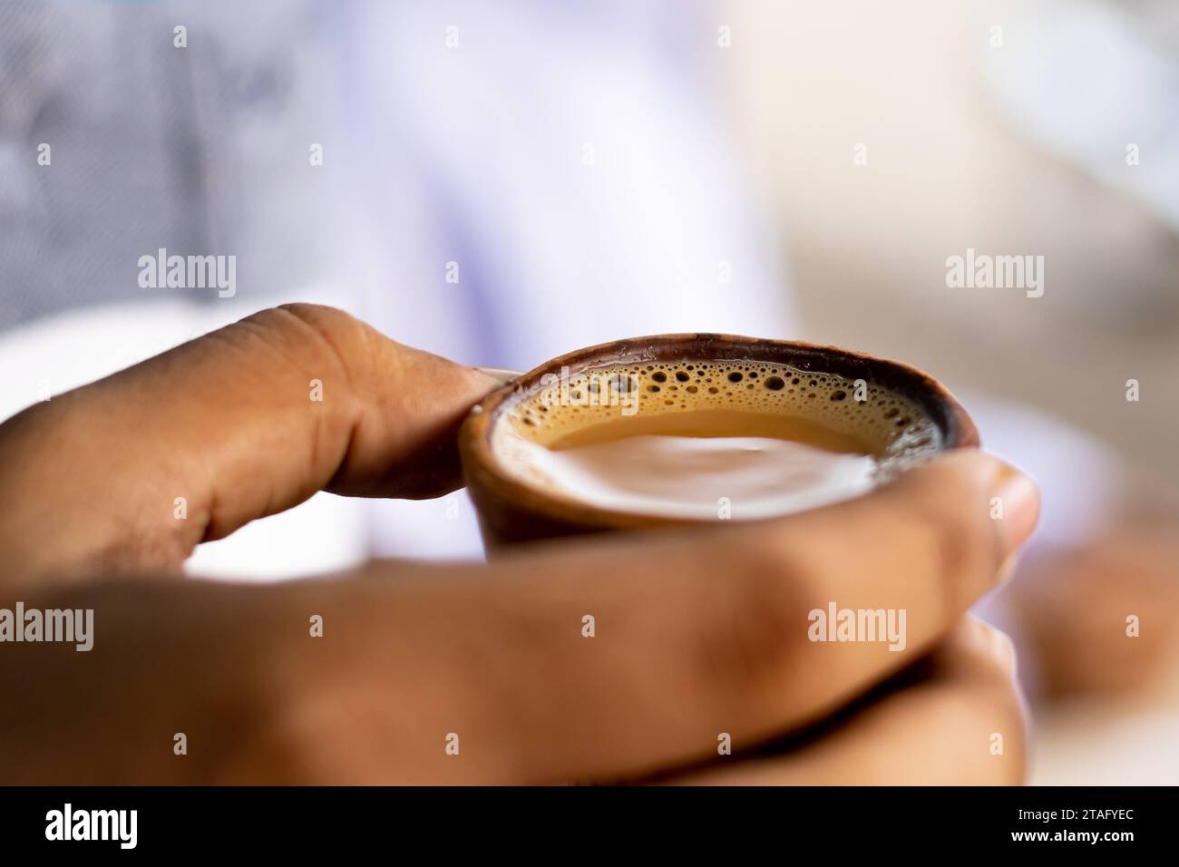 Heißer Milchtee oder Chai in traditionellem Kulhad oder Tontopf oder irdener Tasse, die von Hand gehalten wird. Das ist ein sehr beliebtes Getränk in indien. Stockfoto