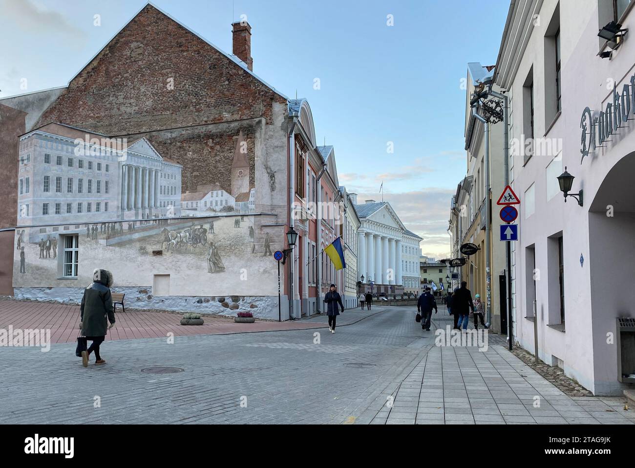 Tartu, Estland. Oktober 2023. Ein Wandbild (links) in der University Street zeigt das Hauptgebäude der Universität von Tartu, das nicht weit entfernt ist. Estlands zweitgrößte Stadt, Tartu, wird 2024 Kulturhauptstadt Europas sein. Quelle: Alexander Welscher/dpa/Alamy Live News Stockfoto