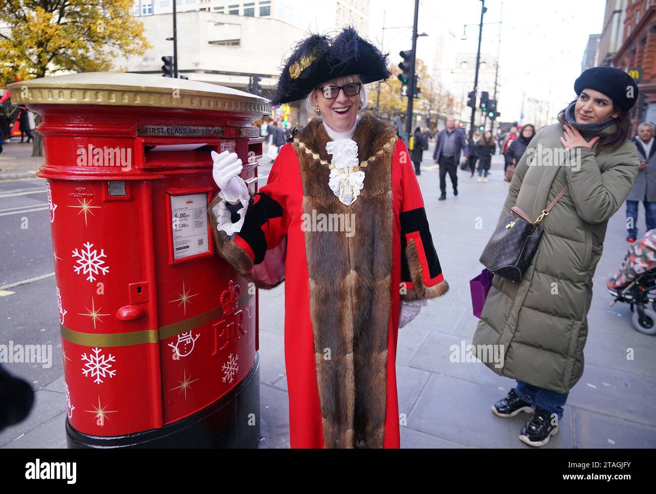 Patricia McAllister, Lord Mayor of Westminster, enthüllt eine Royal Mail Christmas Postbox in der Oxford Street in London. Die festlich dekorierten, singenden Postfächer von Royal Mail befinden sich in einigen der geschäftigsten Feststraßen Großbritanniens in London, Swansea, Glasgow und Belfast. Bilddatum: Donnerstag, 30. November 2023. Stockfoto