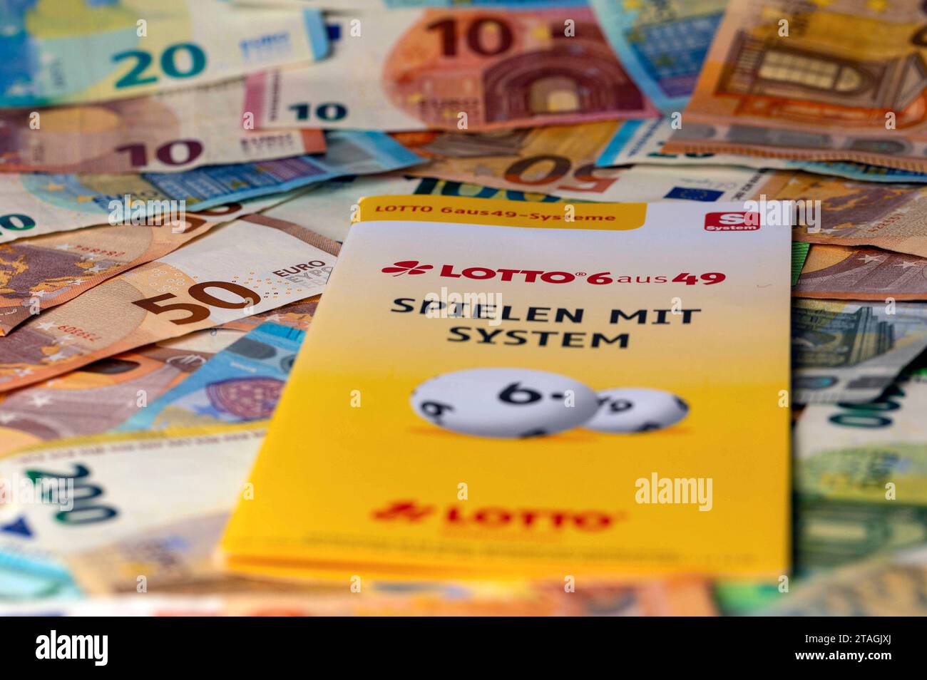 Lotto-Werbeprospekt auf Geldscheinen. In Deutschland betreibt der Deutsche Lotto- und Totoblock als Zusammenschluss der Landes-Lotteriegesellschaften das Lottospiel. Lotto ist ein Glücksspiel, bei dem der Spieler gegen einen finanziellen Einsatz auf das Ziehen vorher getippter Zahlen aus einer begrenzten Zahlenmenge gesetzt. Symbolfoto, Themenfoto *** Lottowerbung auf Banknoten in Deutschland betreibt das Deutsche Lotto und Totoblock, ein Verband staatlicher Lottogesellschaften, das Lottospiel Lotto ist ein Glücksspiel, bei dem der Spieler auf die Gewinnung der zuvor ausgewählten Zahlen f setzt Stockfoto