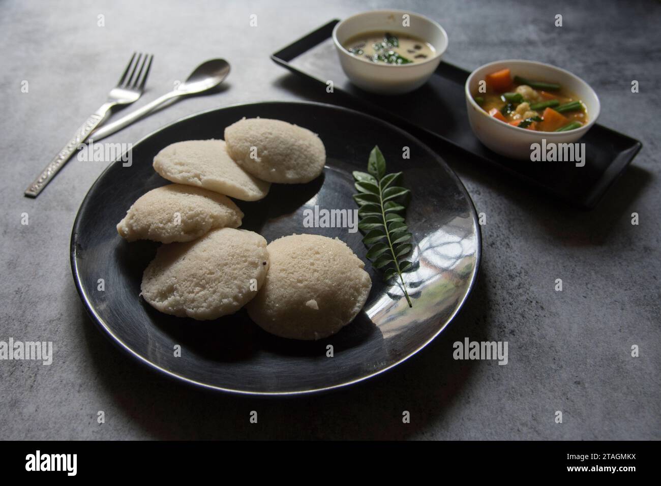Südindisches Essen Idli Stücke und Sambar Stockfoto