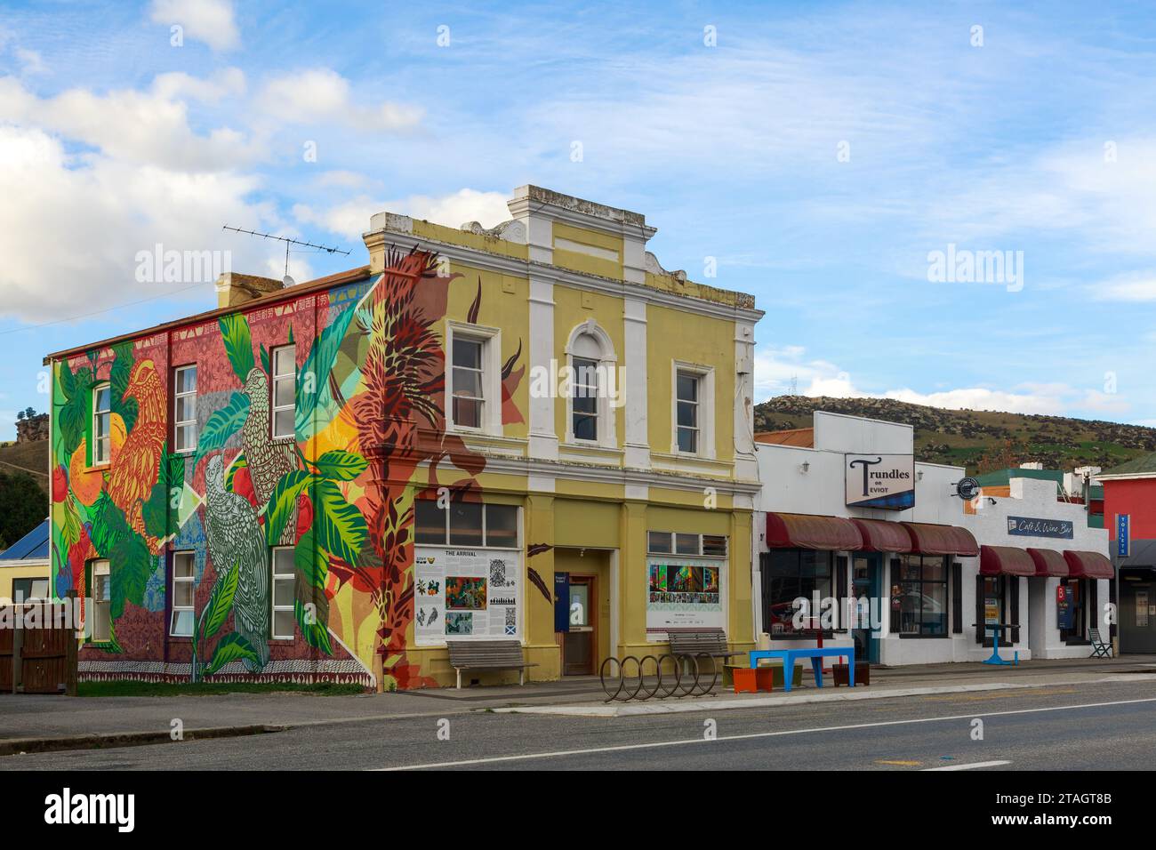 Ein Wandgemälde namens „The Arrival“, das auf einem historischen Gebäude in Roxburgh, Central Otago, Neuseeland, gemalt wurde Stockfoto