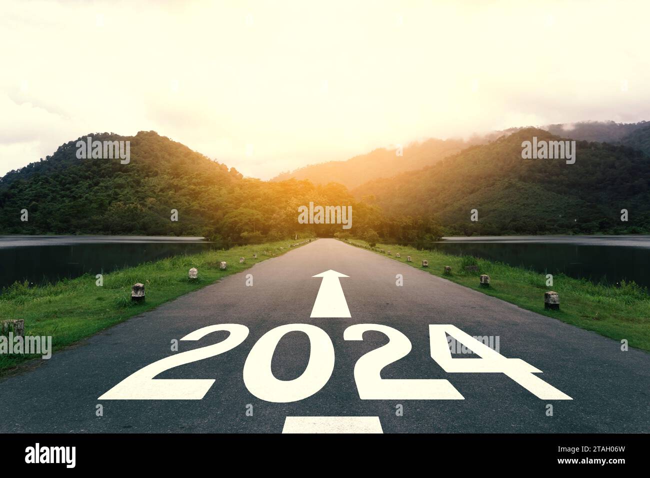 Das neue Jahr 2024 oder ein einfaches Konzept. Text 2024 geschrieben auf der Asphaltstraße bei Sonnenuntergang. Stockfoto