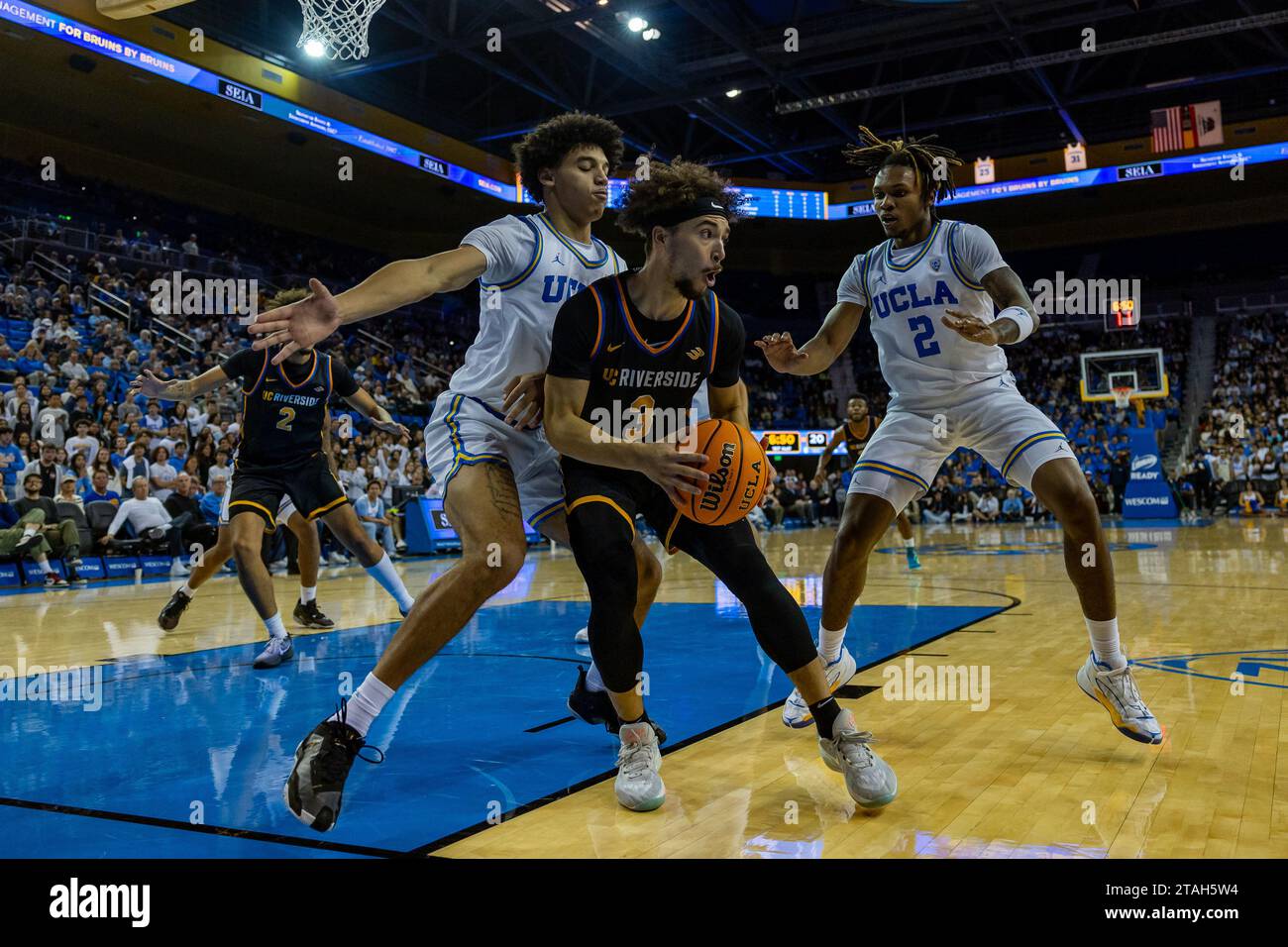 UCLA Bruins Forward Adem Bona (3) versucht, den Ball zu fahren, während UCLA Bruins Wachmann Dylan Andrews (2) und UCLA Bruins Wachmann Ilane Fibleuil (8) während eines NCAA College Basketballspiels am Donnerstag, den 30. November 2023 in Los Angeles bewacht wird. UCLA besiegte UCR 66-65. (Louis Chen/Bild des Sports) Stockfoto