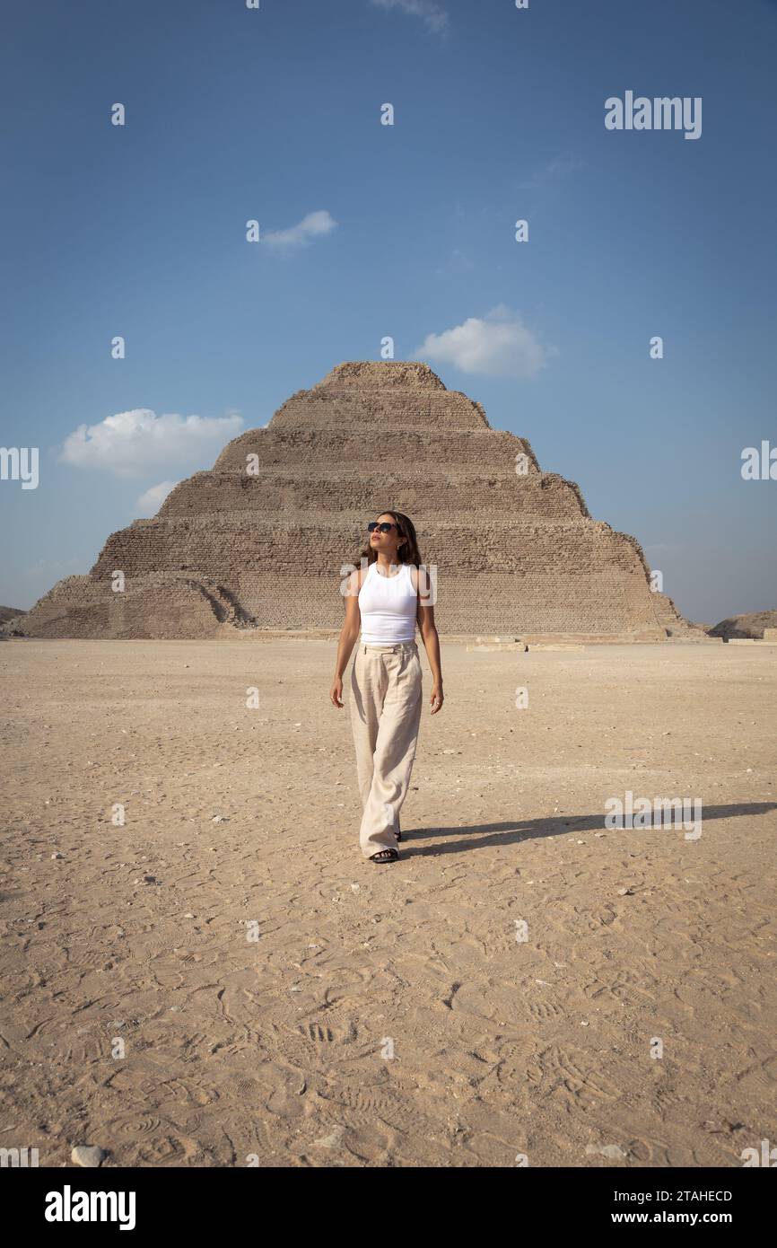 Lateinische Frau mit Sonnenbrille, die vor der Saqqara-Pyramide läuft Stockfoto