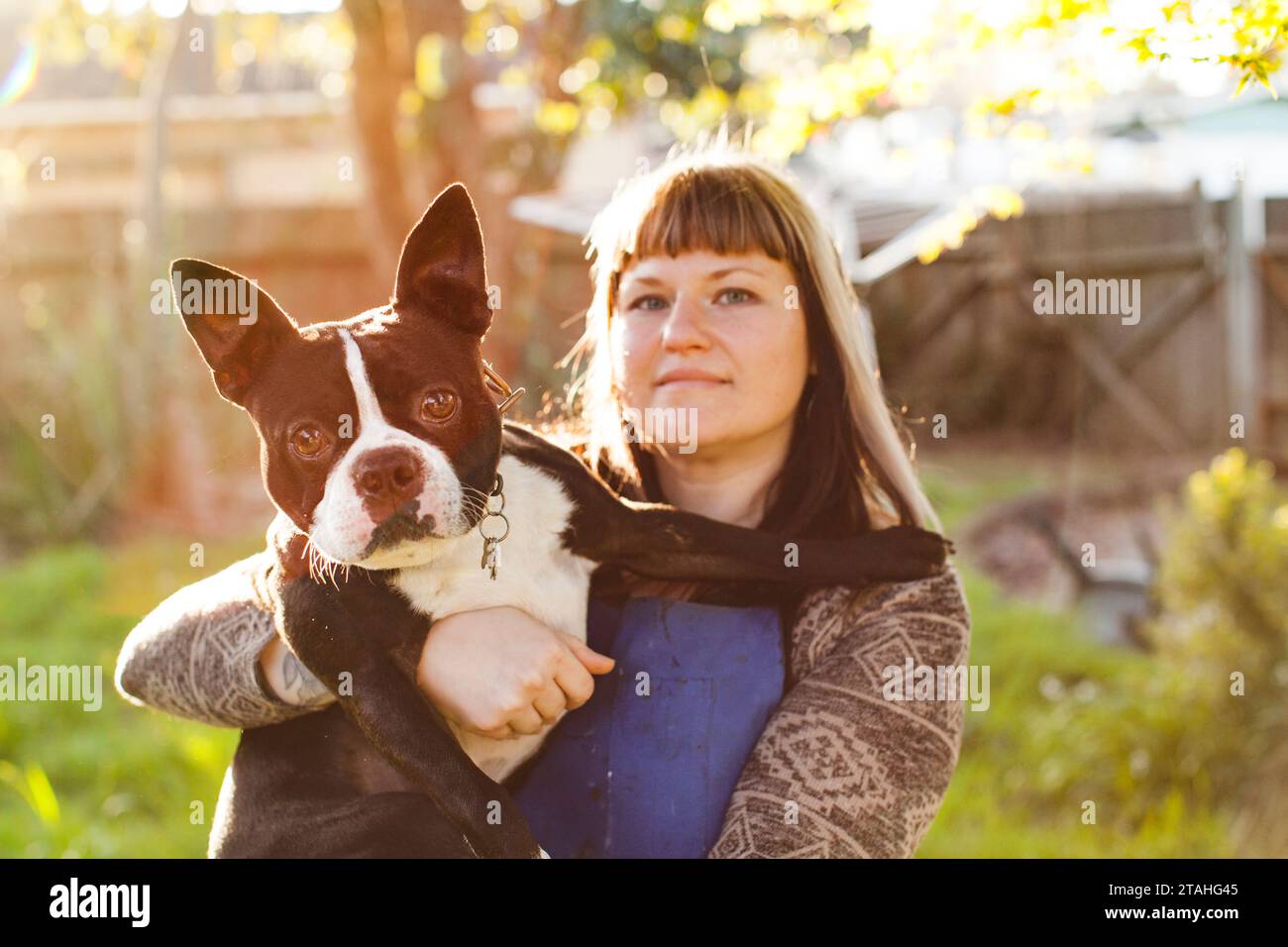 Porträt einer Frau, die einen kleinen Hund auf dem Hof hält Stockfoto