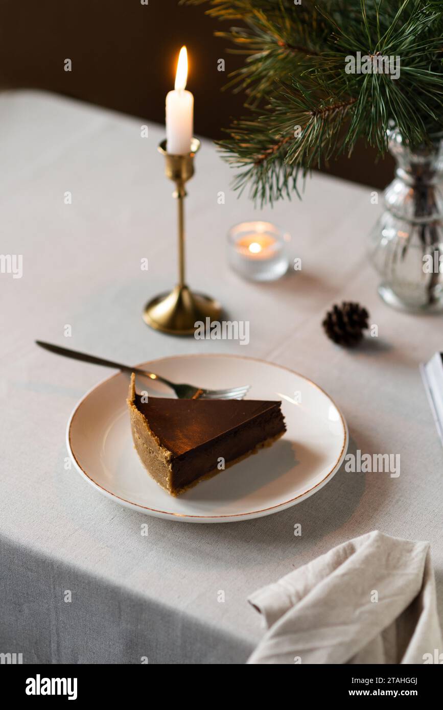 Gemütliche Atmosphäre mit Tannenzweigen, Kerzen und Kuchen Stockfoto