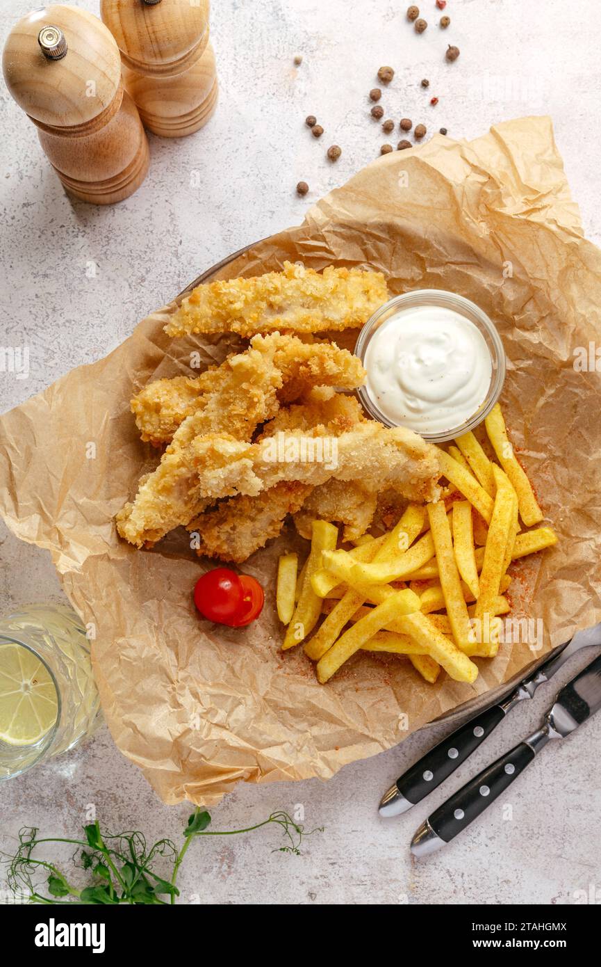 Fish and Chips auf einem Teller mit Sauce Stockfoto