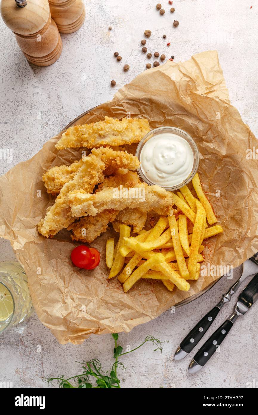 Fish and Chips auf einem Teller mit Sauce Stockfoto