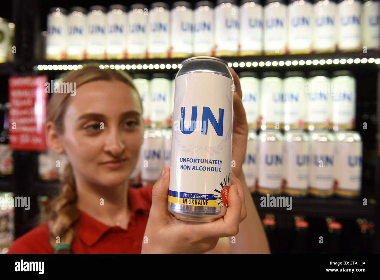 Lviv, Ukraine - 1. Juli 2022: Ein Mitarbeiter des Bierrestaurants „Prawda“ zeigt eine Dose ihres eigenen Biers, das vor Ort gebraut wird und den Namen „UN, leider, Stockfoto