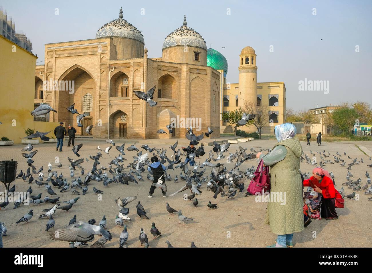 Khujand, Tadschikistan - 29. November 2023: Menschen gehen neben dem Mausoleum von Scheich Muslihiddin in Khujand, Tadschikistan. Stockfoto