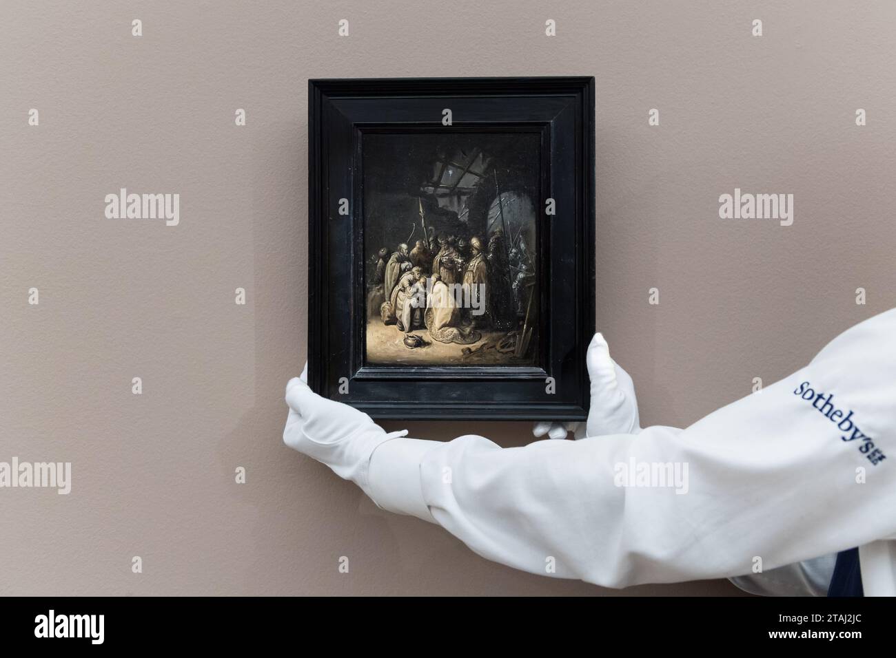 LONDON, VEREINIGTES KÖNIGREICH – 1. DEZEMBER 2023: Ein Techniker hält ein wiederentdecktes Gemälde von Rembrandt Harmensz. Van Rijn „The Adoration of the Kings“, geschätzte £10.000.000-15.000.000 während eines Fotoanrufs im Auktionshaus Sotheby's, bei dem die Höhepunkte der Old Masters Week Sales am 1. Dezember 2023 in London, Großbritannien, gezeigt werden. Der Abendverkauf der Masters Week im Dezember erstreckt sich vom frühen 15. Bis zum frühen 20. Jahrhundert und bietet eine große Auswahl an bemerkenswerten Werken aus fast allen Genres. (Foto: Wiktor Szymanowicz/NurPhoto) Stockfoto