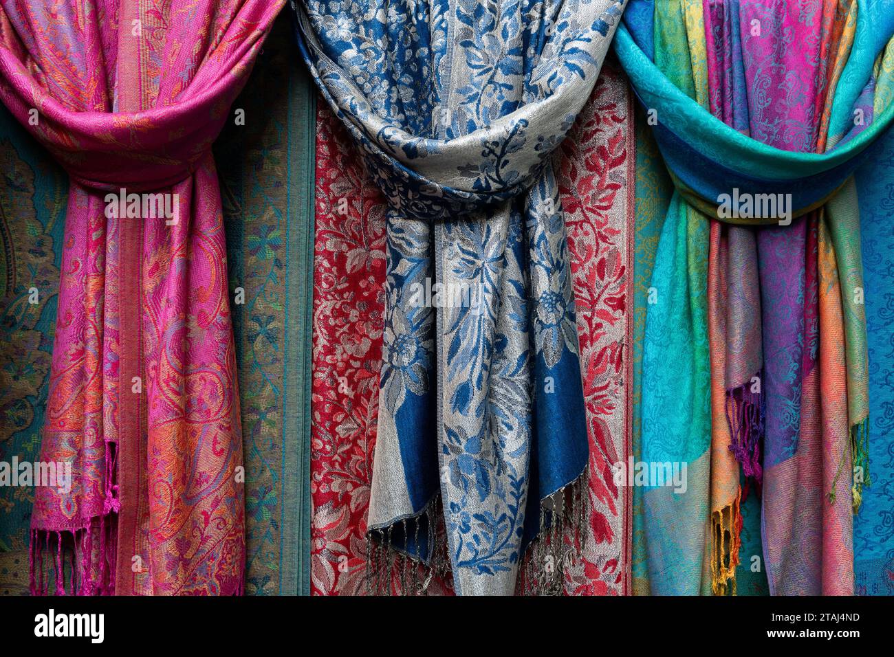 Farbenfrohe, weiche Damenschals aus Pashmina-Kaschmir, die an einem Präsentationsständer auf einem Markt im Freien in Italien befestigt sind. Stockfoto