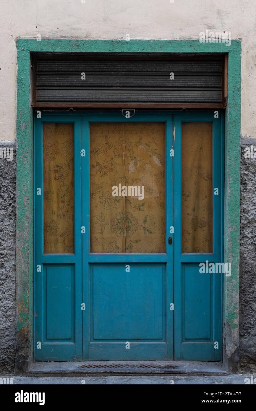 Eine blaue Tür und grüne Fenster am Eingang zu einem Gebäude in Florenz, Toskana, Italien Stockfoto