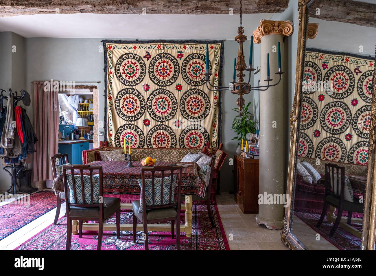 Suzani Wandbehang mit Teppich, der als Tischdecke im Essbereich des georgianischen Scheunenbaus in Tetbury, Gloucestershire, Großbritannien, verwendet wurde. Stockfoto