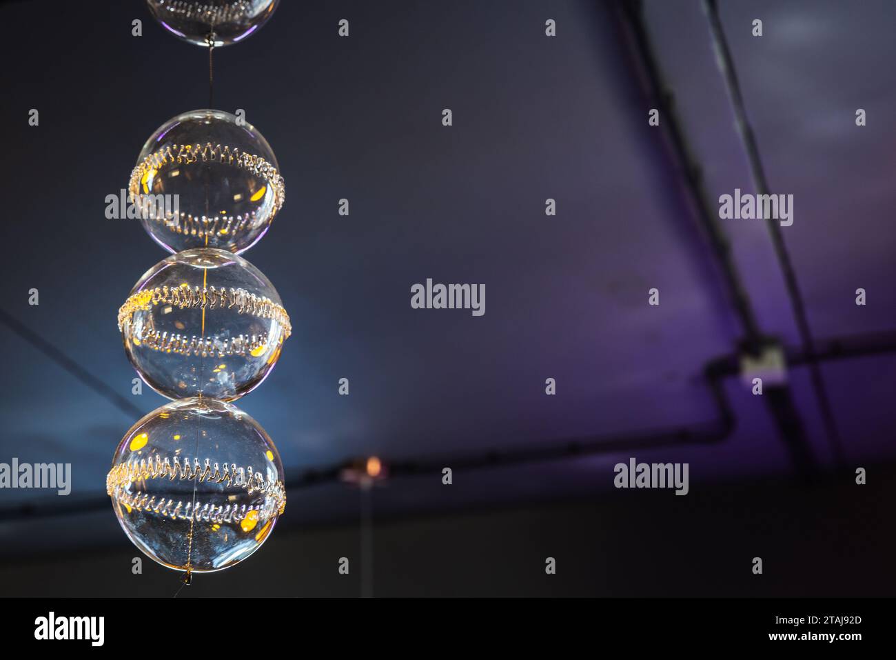 Weihnachtsdekoration, transparente Glaskugeln hängen in einem dunklen Raum Stockfoto
