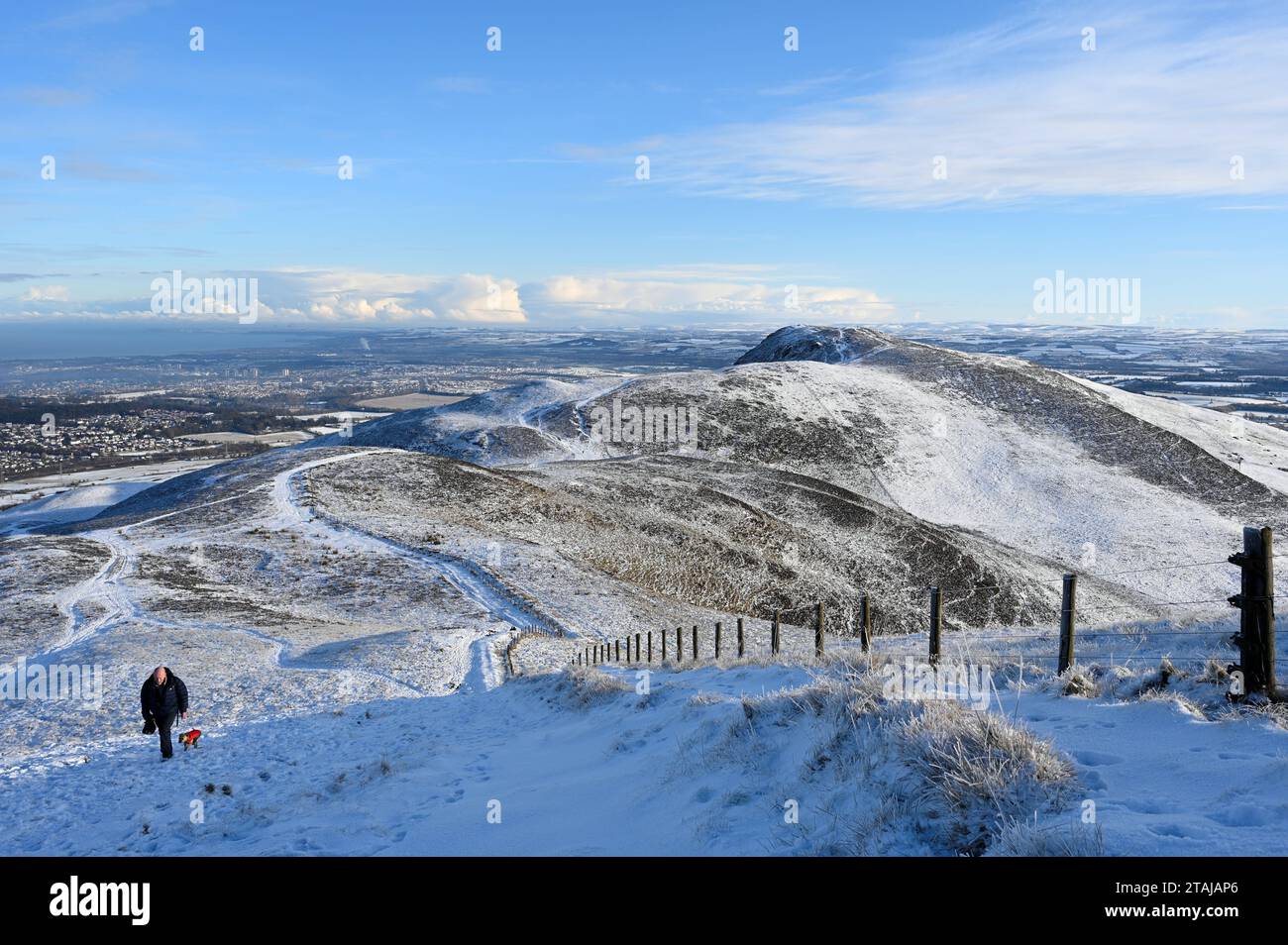 Edinburgh, Schottland, Großbritannien. Dezember 2023. Schnee kommt im Pentland Regional Park an. Walker auf dem Weg nach Allermuir mit Caerketton im Hintergrund. Quelle: Craig Brown/Alamy Live News Stockfoto