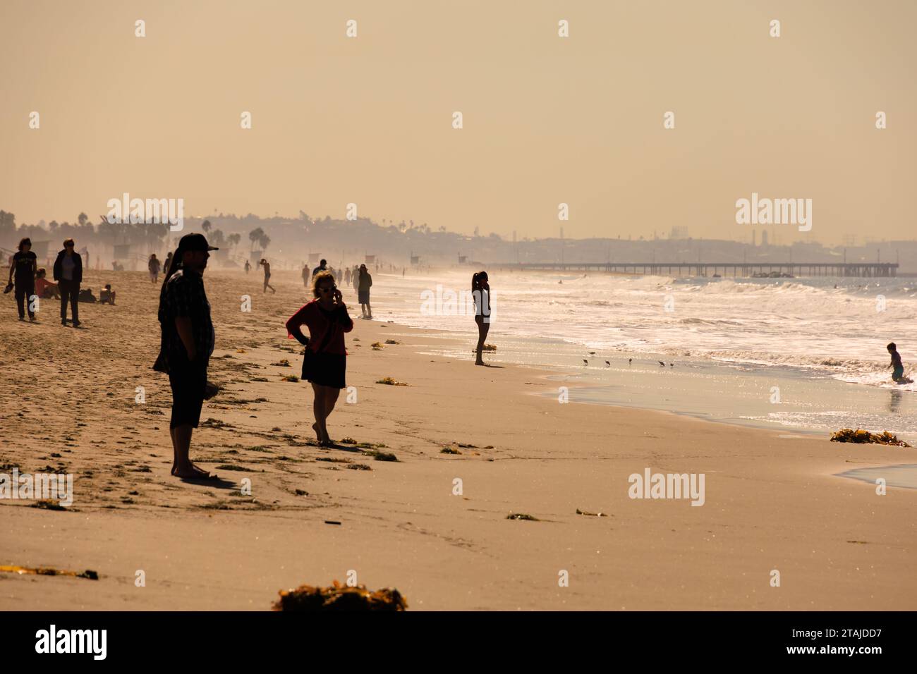 Silhouetten von Menschen, die am Strand stehen, wenn die Sonne untergeht. Santa Monica, Kalifornien, Vereinigte Staaten von amerika. USA. Oktober 2019 Stockfoto