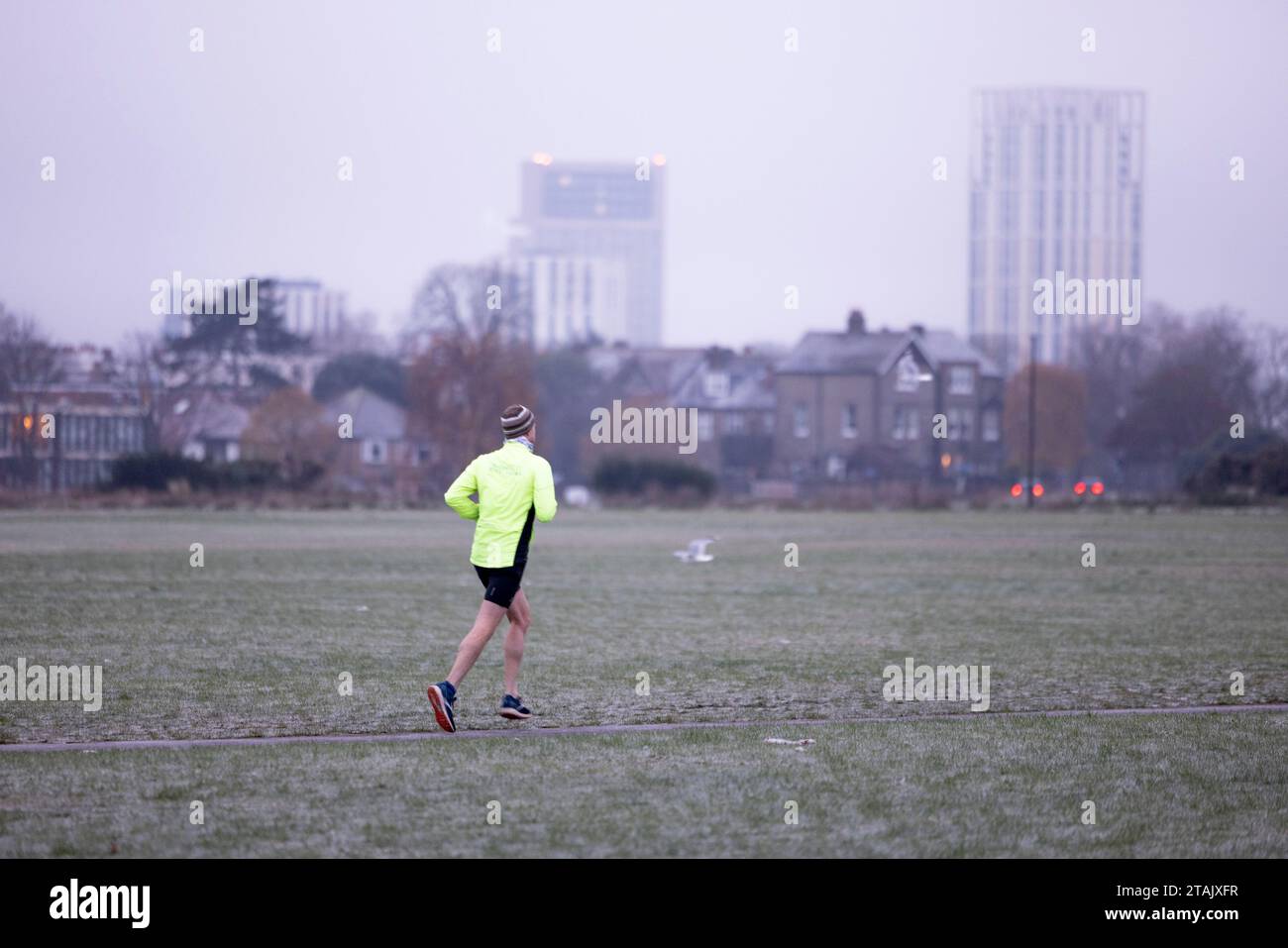 London, Großbritannien. Dezember 2023. Ein Mann, der im eisigen Morgenwetter im Blackheath Park in London gelaufen ist. Greenwich Park und Blackheath Park im Südosten Londons sind frostbedeckt, während sich die Kälte aus Skandinavien weiter nach Süden zieht. Die Temperaturen erreichten in London zwei aufeinander folgende Nächte lang den Gefrierpunkt, da das kältere Wetter anhält und die niedrigen Temperaturen über das Wochenende prognostiziert werden. Quelle: SOPA Images Limited/Alamy Live News Stockfoto