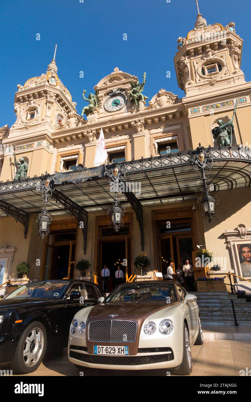 Teure Autos, Leute, die sie sehen und das Äußere von Monte Carlo / Monte-Carlo Casino, Monaco. Sonniger Sommertag mit Sonne und blauem Himmel. (135) Stockfoto
