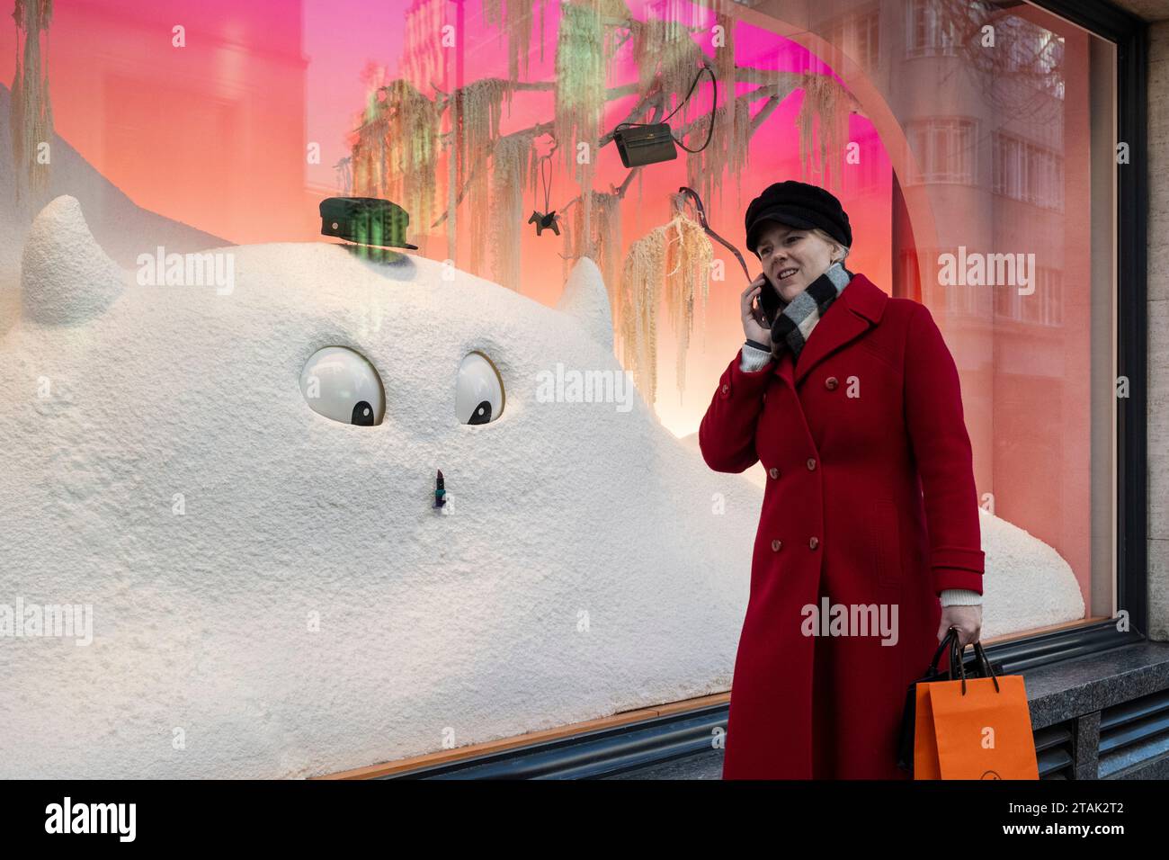 London, Großbritannien. 1. Dezember 2023. Ein Käufer kommt am Fenster des Luxusgeschäfts Hermes in der Bond Street vorbei, das zu Weihnachten mit einem abscheulichen Schneemann mit bewegten Augen dekoriert wurde. Die Einzelhändler hoffen auf höhere Umsätze während der Weihnachtszeit, da die Krise der Lebenshaltungskosten anhält. Quelle: Stephen Chung / Alamy Live News Stockfoto