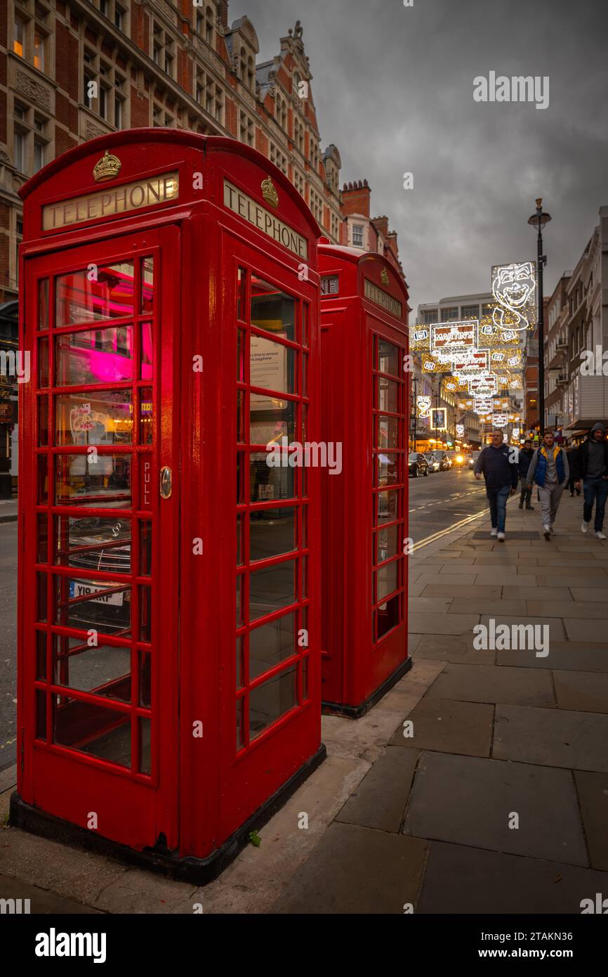 London, Großbritannien - 20. November 2023: Rote öffentliche Telefonzellen in der St Martin's Lane im Zentrum von London. Stockfoto