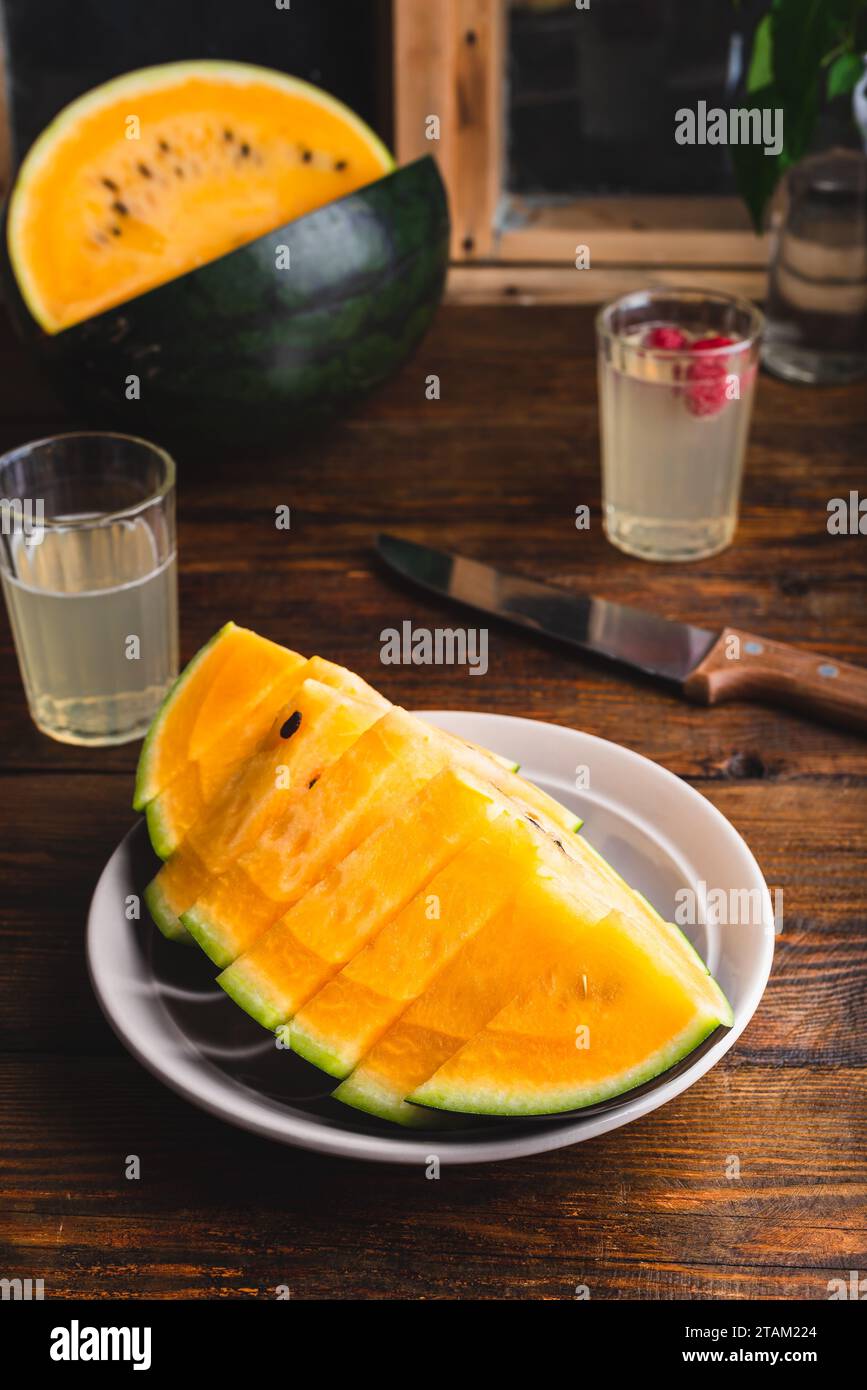 Süßgelbe Wassermelone in Scheiben auf einem Holztisch Stockfoto