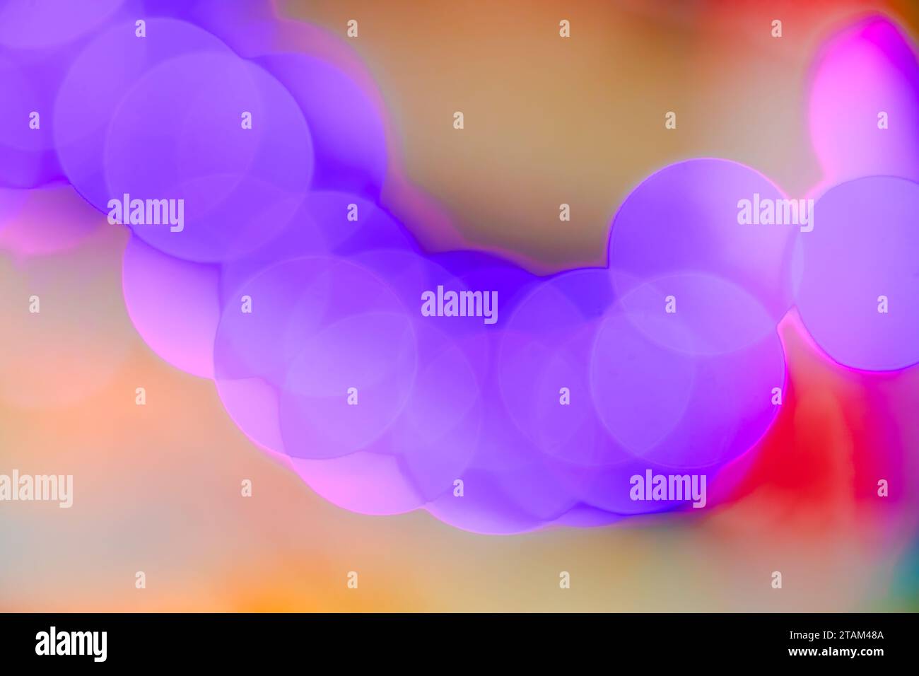 Abstrakte, unscharfe lila weiche, glatte Bokeh-Lichtkreise, die auf farbenfrohem Hintergrund leuchten, Nahaufnahme Stockfoto