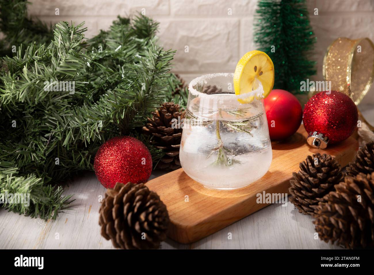 Schneekugel-Cocktail. Weihnachtsgetränk, kreatives Festgetränk im Glas, dekoriert mit Rosmarinzweig wie eine weihnachtskiefer und Zitrus sli Stockfoto