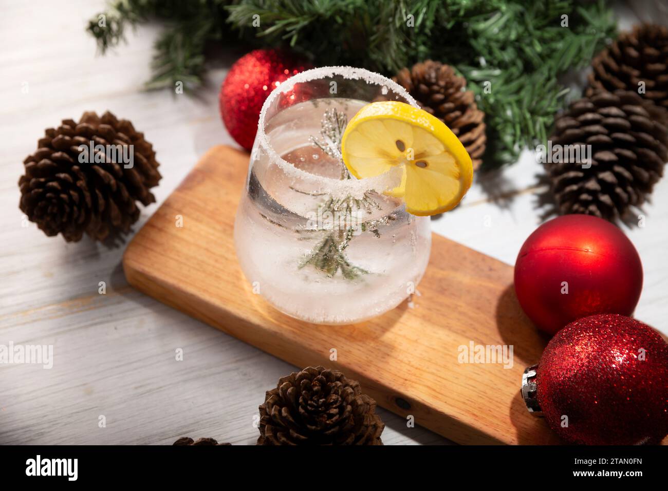 Schneekugel-Cocktail. Weihnachtsgetränk, kreatives Festgetränk im Glas, dekoriert mit Rosmarinzweig wie eine weihnachtskiefer und Zitrus sli Stockfoto