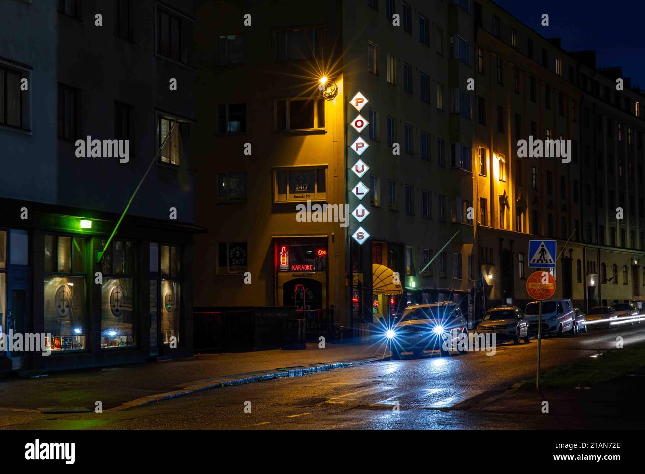 Blick auf die Straße Aleksis Kiven Katu mit Karaoke-Bar Populus nach Einbruch der Dunkelheit im Bezirk Harju in Helsinki, Finnland Stockfoto