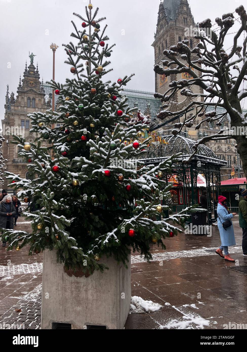 Hamburg, Deutschland. Dezember 2023. Ein Betonblock mit einem Weihnachtsbaum steht vor einem Weihnachtsmarkt. Nach den jüngsten Festnahmen wegen angeblicher Planung von Terroranschlägen auf Weihnachtsmärkten hält das Hamburger Innenministerium die Bedrohung für weiterhin hoch. Nach dem Lkw-Angriff auf den Berliner Breitscheidplatz im Dezember 2016, bei dem zwölf Menschen ums Leben kamen, wurden die Hamburger Weihnachtsmärkte mit Betonsteinen gesichert. Autor: Thomas Müller/dpa/Alamy Live News Stockfoto