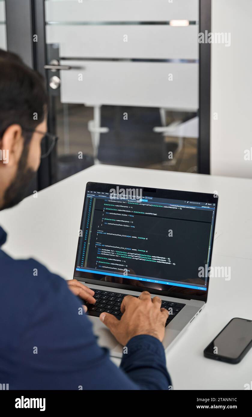 Geschäftiger Softwareentwickler, der im Büro am Computer arbeitet. Über die Schulter Stockfoto